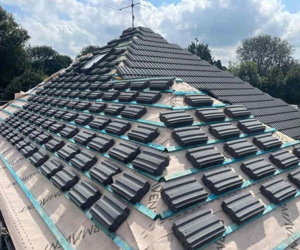 This is a photo of a new hip roof being installed. New felt, battens, and grey tiles have been installed, also a new velux window. Works carried out by WBN Roofing Rossington